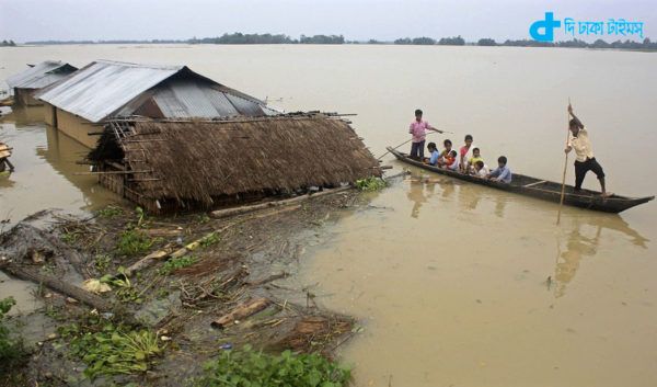 Flood-affected local residents move to safer places on a boat after heavy rains at Jajimukh village