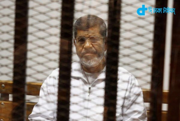 FILE - In this file photo taken Thursday, May 8, 2014, Egypt's ousted Islamist President Mohammed Morsi sits in a defendant cage in the Police Academy courthouse in Cairo, Egypt. Besides the current charges against him of conspiring with foreign groups, inciting the murder of his opponents and orchestrating prison breaks during the 2011 uprising that toppled his predecessor, Hosni Mubarak, Egypt's state prosecutor is now investigating allegations that Morsi leaked secret documents to Qatar via the Doha-based Al-Jazeera broadcaster, judicial officials said Wednesday, Aug. 27. (AP Photo/Tarek el-Gabbas, File)